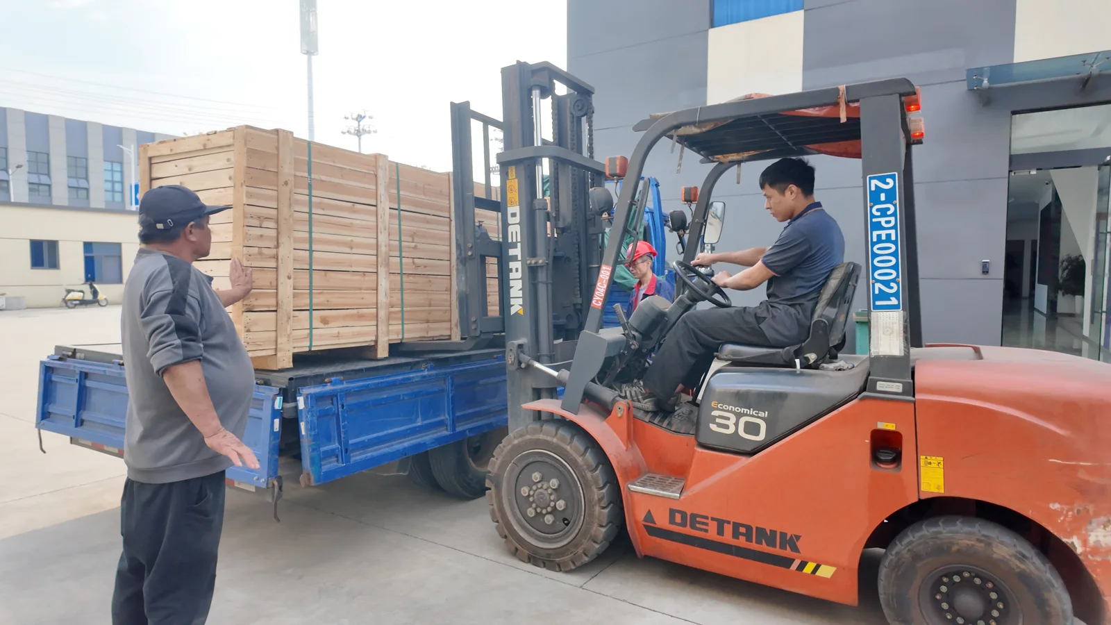 A forklift positioning wooden crates on a blue truck at the Changyu factory.